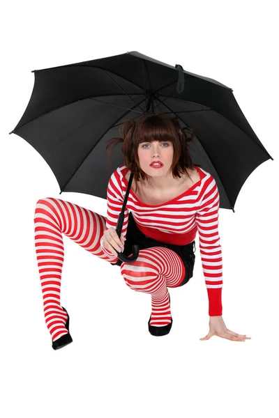 Woman with umbrella crouching — Stock Photo, Image