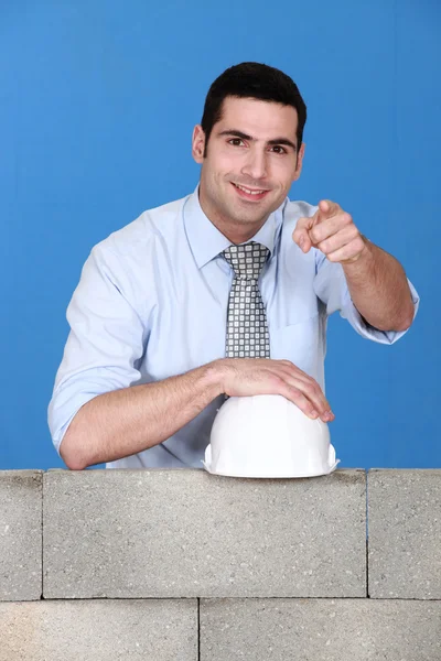 Architect stood by wall pointing — Stock Photo, Image