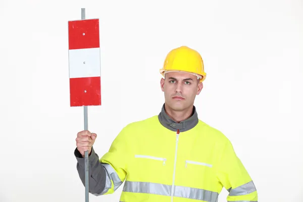 A traffic guard holding up a sign — Stock Photo, Image
