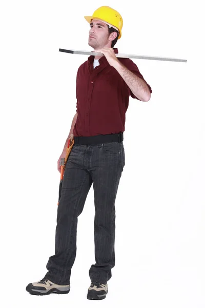 Ambachtsman uitvoering materialen op zijn schouder — Stockfoto