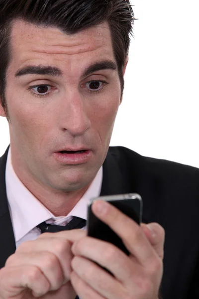Businessman shocked by text message — Stock Photo, Image