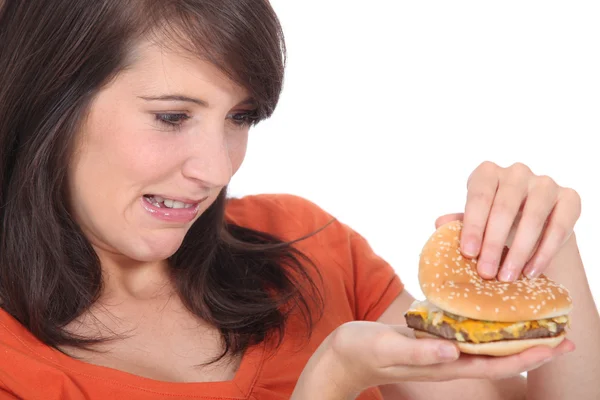 Brunette regardant un hamburger — Photo