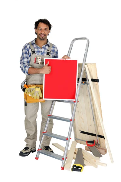 Carpenter giving the thumbs up to a board left blank for your message — Stock Photo, Image