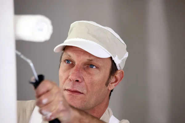 Άνθρωπος που χρησιμοποιεί κυλινδρικό χρωστήρα στον τοίχο — Φωτογραφία Αρχείου