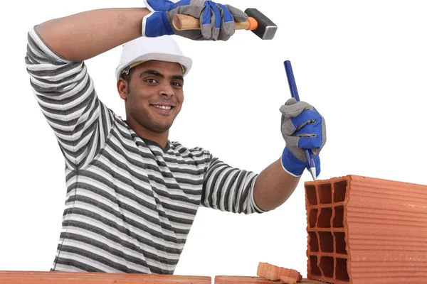 Man chipping away at brick — Stock Photo, Image