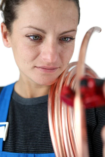 Female plumber at work with copper piping — Stock Photo, Image