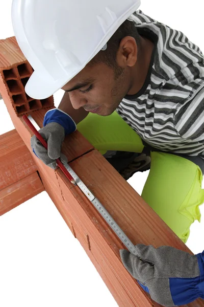 Mason measuring length of brick — Stock Photo, Image