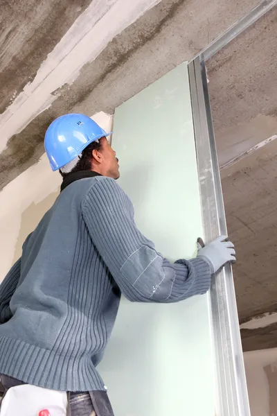 Worker slotting plasterboard into place — Stock Photo, Image