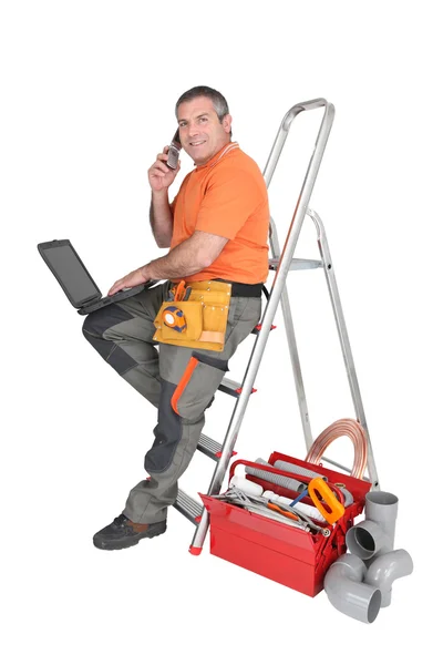 Trabalhador manual rodeado por equipamento — Fotografia de Stock