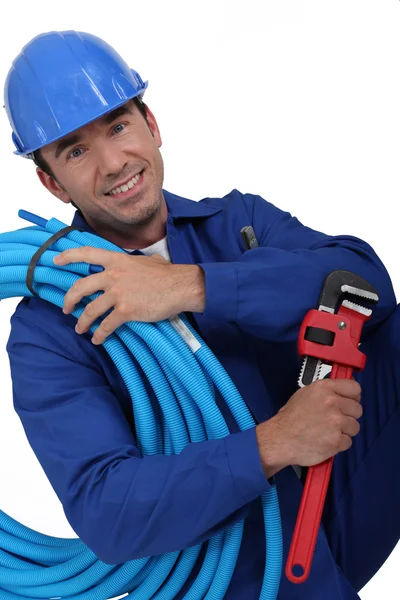 Trabalhador com capacete azul ajoelhado — Fotografia de Stock
