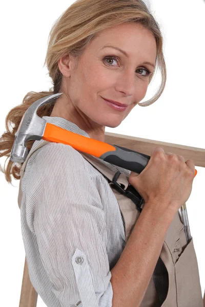 Carpintero hembra con martillo y marco de madera — Foto de Stock