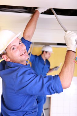 Electricians working on roof clipart