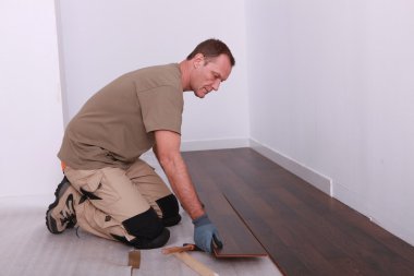 Man installing parquet flooring clipart