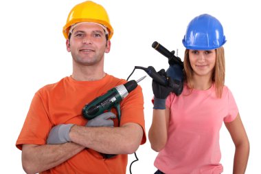 Female and male tradespeople holding electric drill clipart