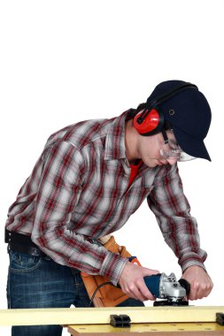 Man using router on plank of wood clipart