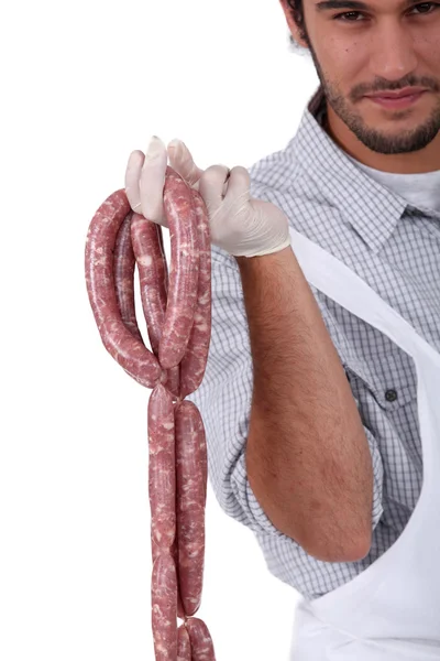 A butcher holding sausages. — Stock Photo, Image