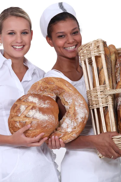 Dois trabalhadores da padaria segurando pão — Fotografia de Stock