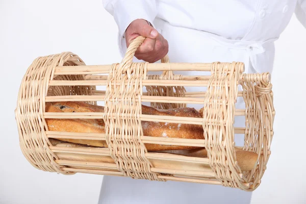 Пекарь с корзиной хлеба — стоковое фото