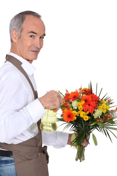 Florist bespruta blommor — Stockfoto