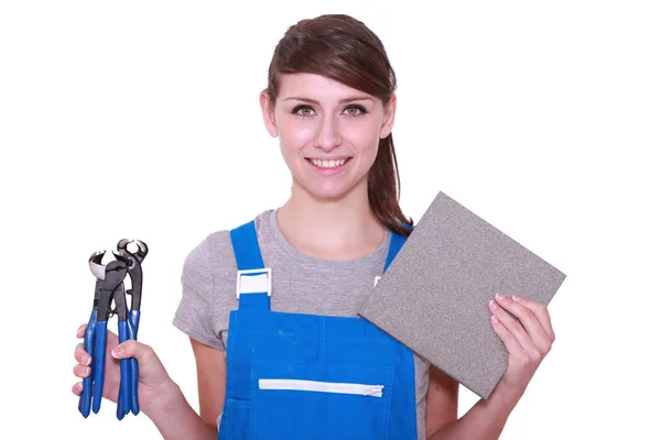 Mujer sosteniendo azulejo y cortadora de azulejos —  Fotos de Stock