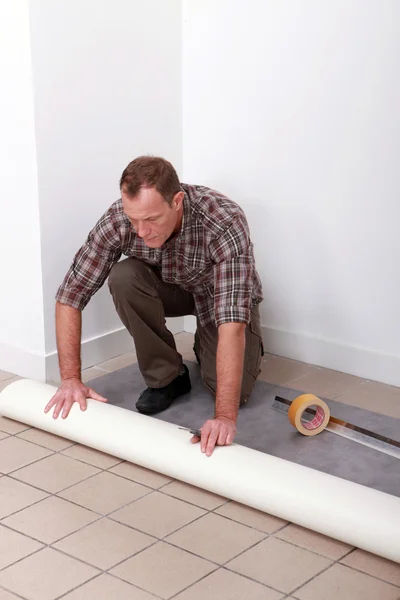 Man unrolling carpet roll — Stock Photo, Image