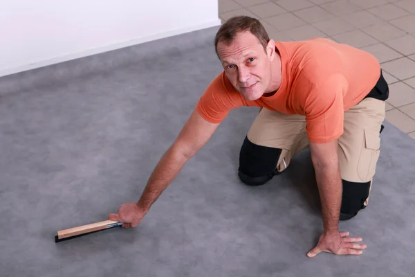 Homme installant un plancher de linoléum — Photo