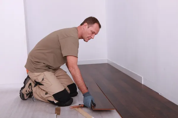 Homem que instala piso em parquet — Fotografia de Stock