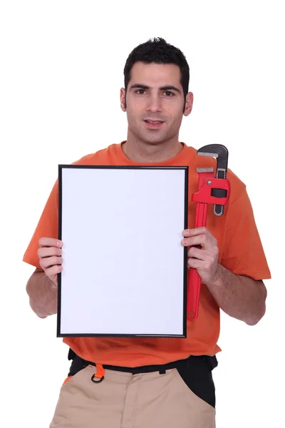 Handyman mostrando um pequeno painel branco — Fotografia de Stock