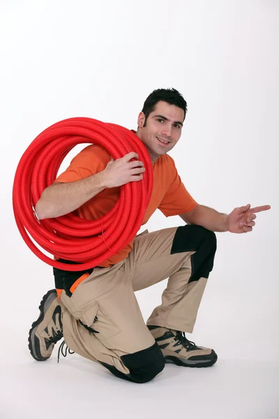Young plumber pointing to his side — Stock Photo, Image