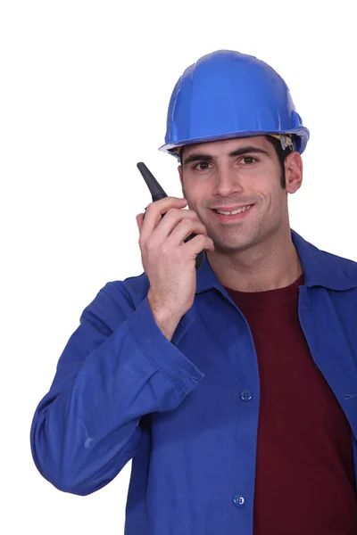 Construction worker speaking into a walkie-talkie — Stock Photo, Image