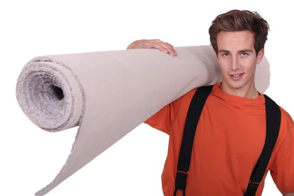 Man die een samengevouwen tapijt — Stockfoto