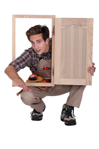 Carpinteiro com porta do armário — Fotografia de Stock
