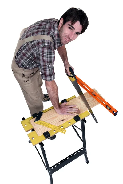 Carpenter sawing a plank — Stock Photo, Image