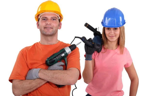 Female and male tradespeople holding electric drill — Stock Photo, Image