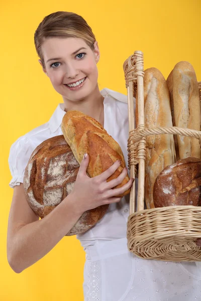 Bageri arbetstagaren innehar korg med bröd — Stockfoto