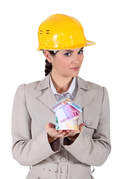 Female architect holding house lade from bank notes — Stock Photo, Image