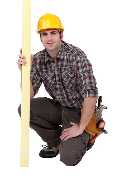 A kneeled male carpenter. — Stock Photo, Image