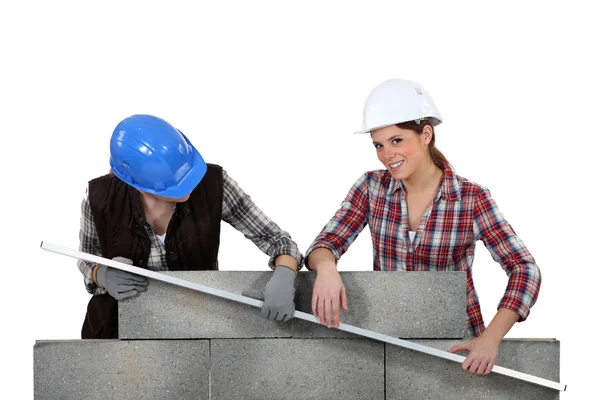 两个女手工业者测量一堵墙 — 图库照片