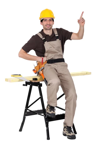 Um carpinteiro apontando para cima e mostrando algo — Fotografia de Stock