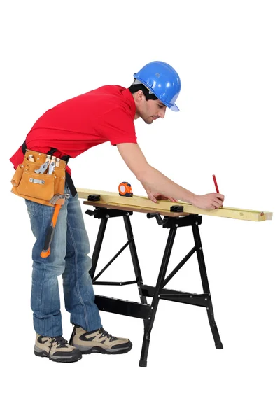 Carpinteiro marcando um pedaço de madeira — Fotografia de Stock