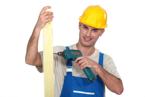 Man drilling hole into wooden plank — Stock Photo, Image