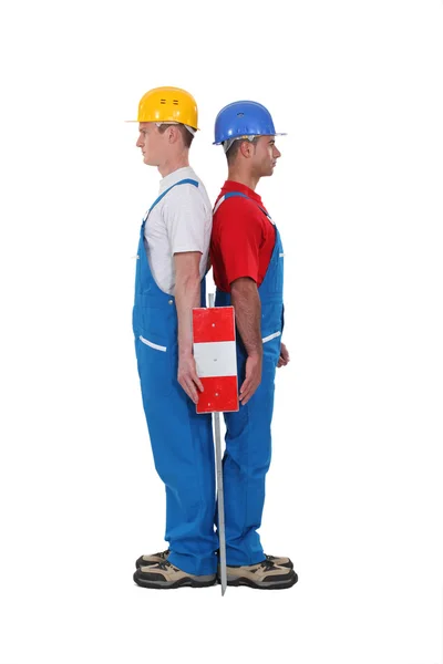 Duo di operai in piedi schiena contro schiena isolati su bianco — Foto Stock