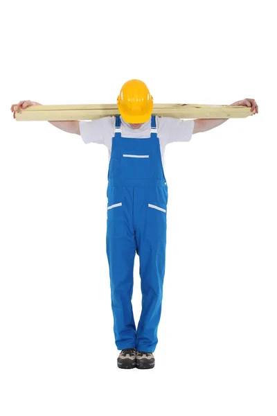 Carpenter with planks of wood along shoulder — Stock Photo, Image
