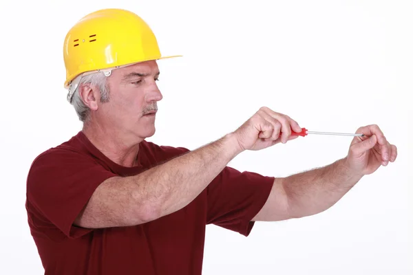 Middle-aged handyman using screw-driver — Stock Photo, Image