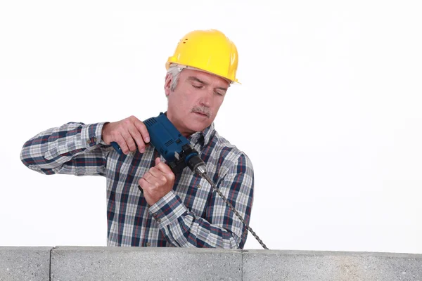 Senior mason drilling into wall — Stock Photo, Image