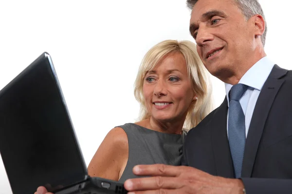 Glücklicher Geschäftsmann und Geschäftsfrau mit Blick auf einen Laptop — Stockfoto