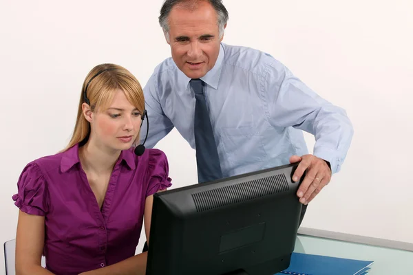 Vrouw en haar baas op een computer — Stockfoto