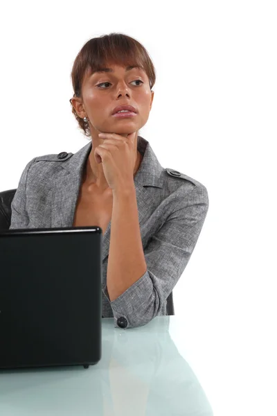 Zakenvrouw zit aan haar bureau met een laptop — Stockfoto