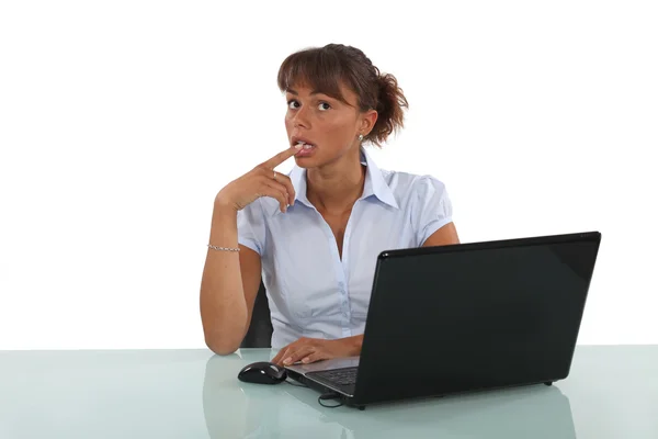 Geschäftsfrau sitzt am Schreibtisch und denkt nach — Stockfoto