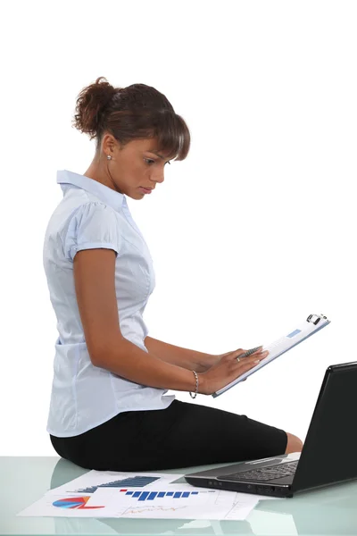 Mulher sentou-se com laptop e clip-board — Fotografia de Stock